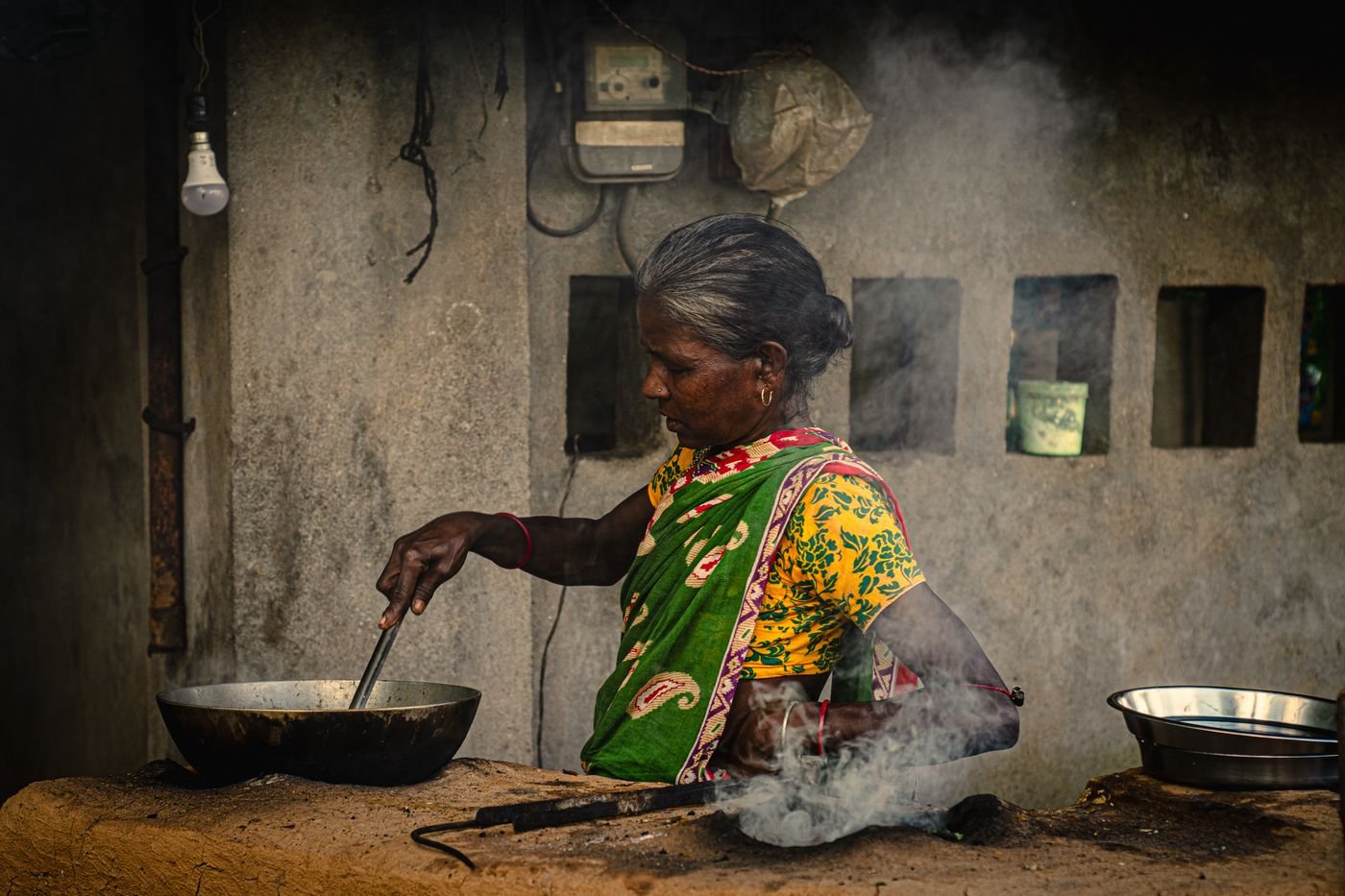 A woman cooking in a traditional village kitchen