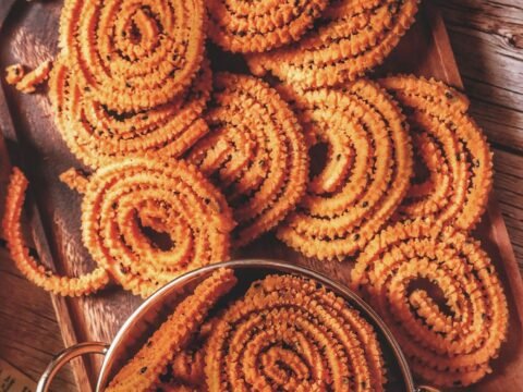 Crispy murukku spirals on a wooden board