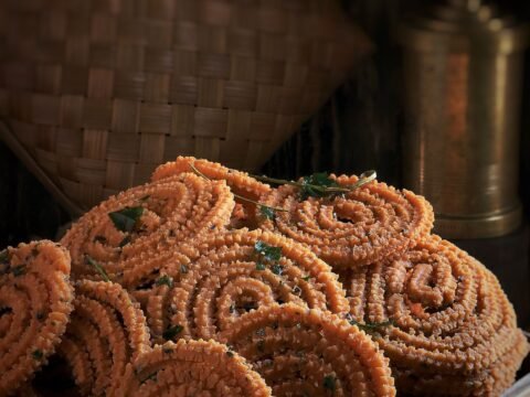 Brown murukku spirals in a woven basket