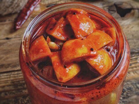 Homemade mango pickle in a glass jar