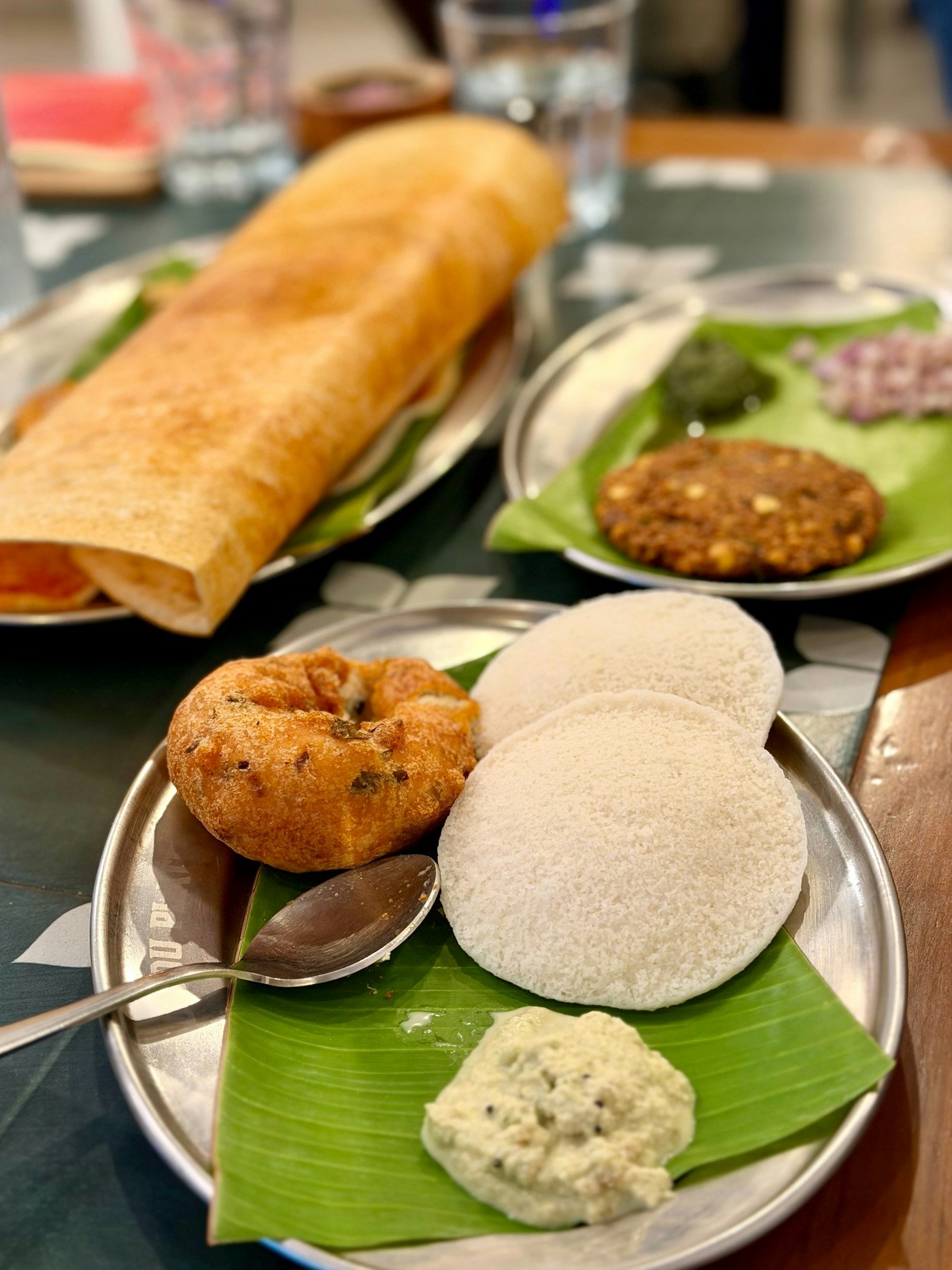 Idli, vada and dosa with chutney on a banana leaf